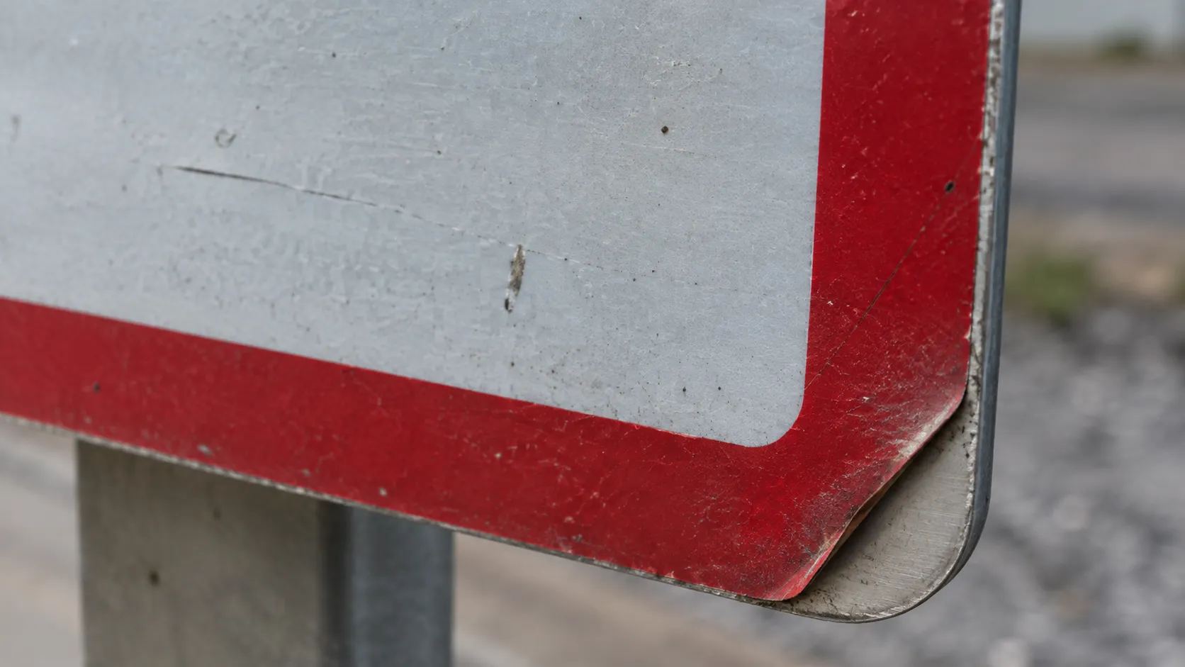 Aged reflective sheeting with minor edge lifting on an aluminum sign.webp