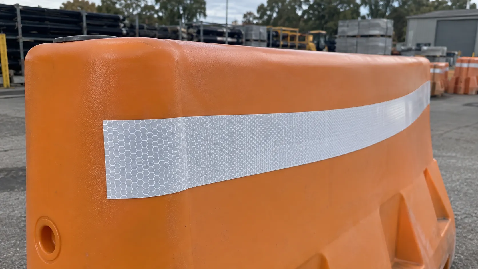 Reflective sheeting applied around a curved plastic safety barrier.webp